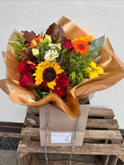Harvest Glow Bouquet - A vibrant, autumn-inspired arrangement in fiery oranges, deep reds and yellow tones. Accented with fresh greenery, rich foliage